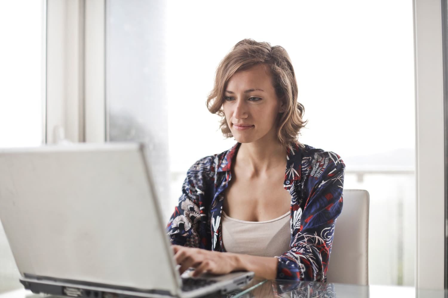 Une femme qui travaille tranquillement sur son ordinateur portable chez elle